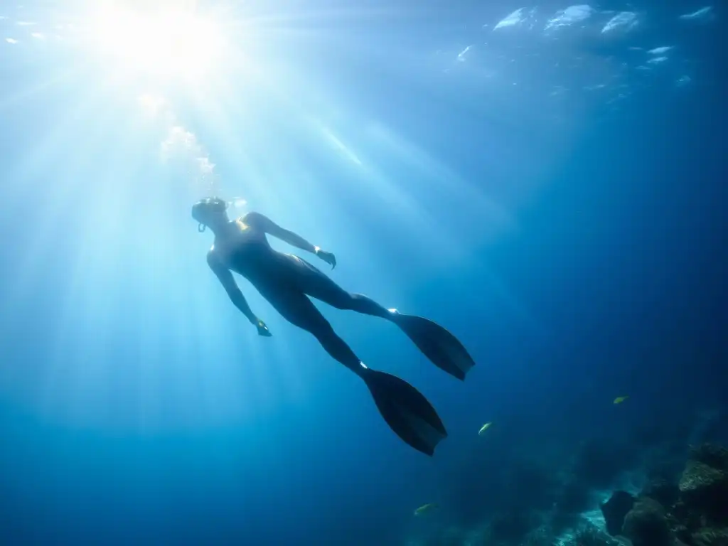 Un buceador libre desciende con gracia entre peces tropicales en un mar azul profundo, evocando historias de superación en el buceo a pulmón